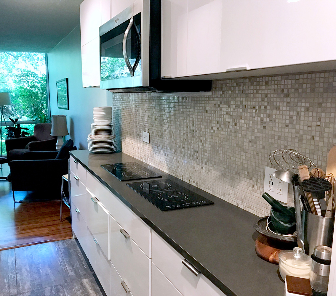 black countertop with white kitchen cabinets.