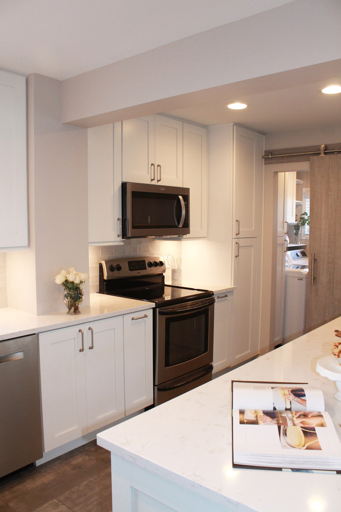 white kitchen with dishwasher, microwave and stove